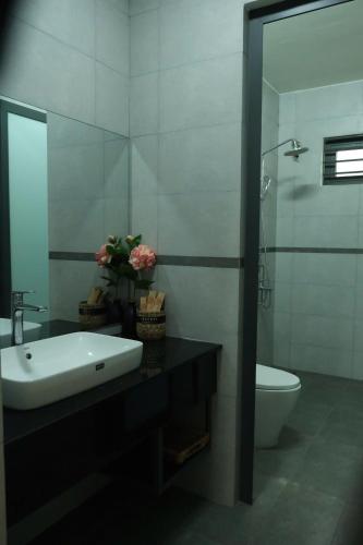 a bathroom with a sink and a toilet and a mirror at An Nhien Homestay - Relaxing Home in Buôn Alê (1)