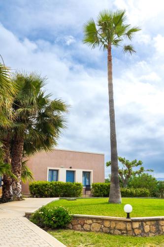 a building with two palm trees in front of it at Emerald Oasis By Azul Collection in Pigianos Kampos