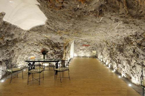 a room in a cave with a table and chairs at La Casa Del Melograno in Furore