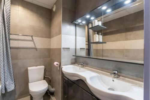 ein Badezimmer mit Waschbecken, Toilette und Spiegel in der Unterkunft Maison charmante à Uzès avec accès à piscine partagée in Uzès