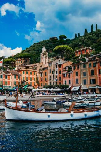 a boat sitting in the water in front of a town at Cozy Rooftop Flat - Steps from the sea - AC and WiFi in Santa Margherita Ligure