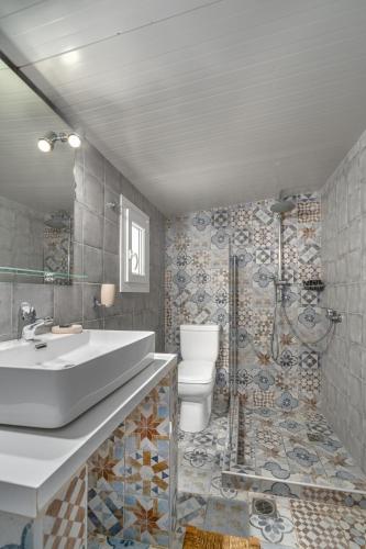 a bathroom with a sink and a toilet and a shower at Amouage Boutique Home in Skiathos Town