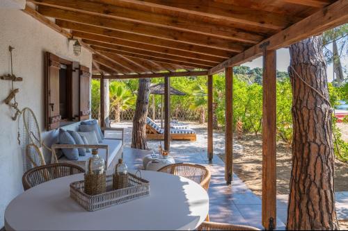 a patio with a table and chairs and a tree at Amouage Boutique Home in Skiathos Town