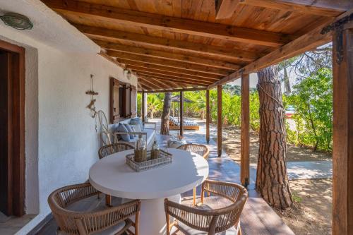 an outdoor patio with a white table and chairs at Amouage Boutique Home in Skiathos Town