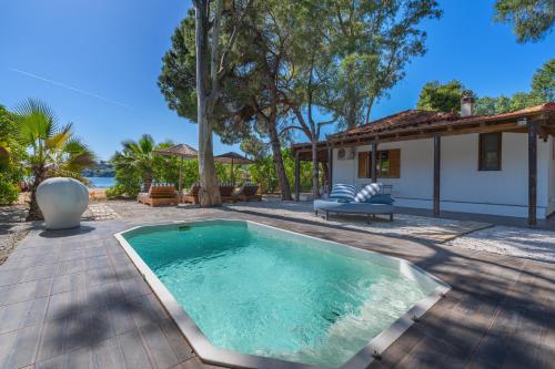 a swimming pool in a yard with a house at Amouage Boutique Home in Skiathos Town