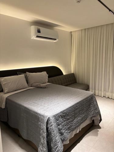 a bedroom with a large bed and a couch at Simple Smart João Pessoa in João Pessoa