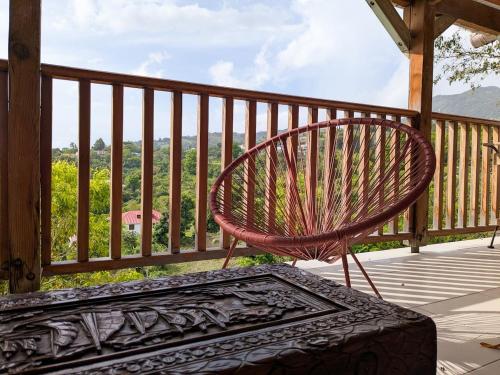 a bench sitting on a porch with a view at Haut de villa, vue imprenable in Baillif