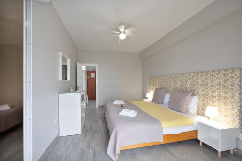 a bedroom with a large bed with a yellow blanket at Casa Limão - Senhora da Rocha, Algarve in Porches