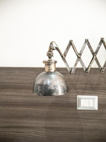 a metal bell on a table next to a lightswitch at La Maison de Monet in Brindisi