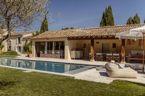 une maison avec une piscine devant une maison dans l'établissement MAS MILLÉSIME - Chambre double - petit déjeuner - piscine - Mas du XVIIIème siècle proche Saint-Rémy-de-Provence, à Mas blanc des Alpilles