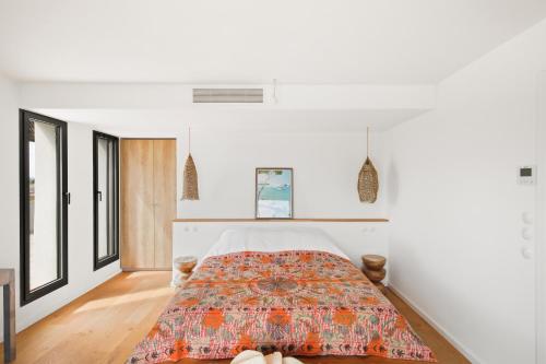 - une chambre avec des murs blancs et un lit avec un couvre-lit coloré dans l'établissement Palmira Duplex jacuzzi, à Hyères