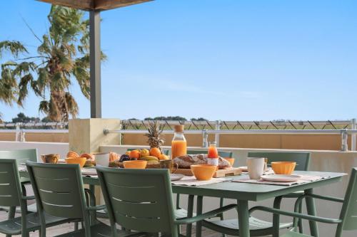 - une table avec des fruits et des jus de fruits sur une terrasse dans l'établissement Palmira Duplex jacuzzi, à Hyères