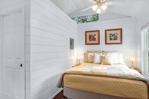 a bedroom with a bed with white walls and a window at Tiny House on the Hill in New Braunfels