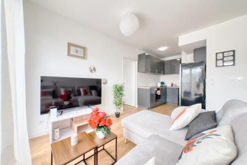 un salon blanc avec un canapé et une table dans l'établissement Appartement prestige 5 personnes, à Saint-Ouen