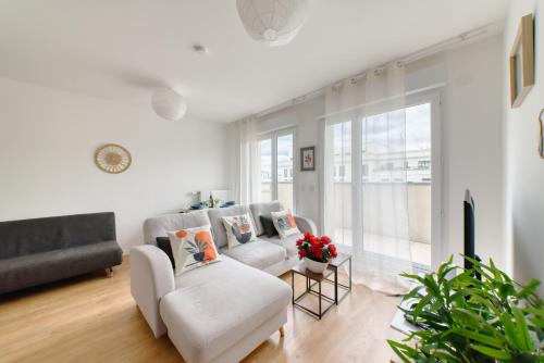 - un salon avec deux chaises blanches et un canapé dans l'établissement Appartement prestige 5 personnes, à Saint-Ouen