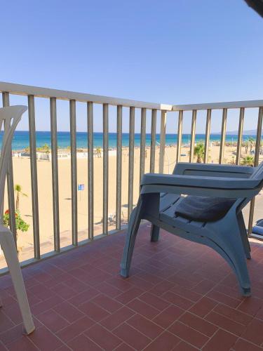 un banc bleu assis sur un balcon donnant sur la plage dans l'établissement Soleil couchant aux reflets miel de la terre, à Canet