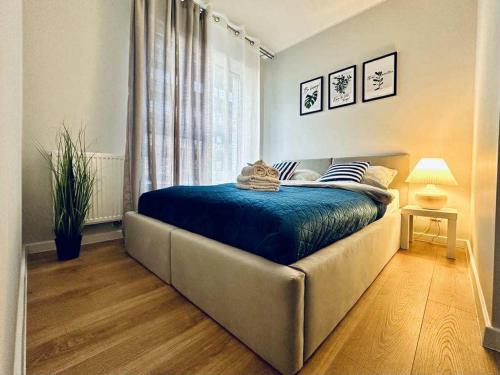 a bedroom with a bed with blue sheets and a window at Na Fali 4 Aquapark Reda in Rumia