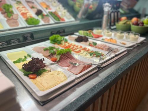 a buffet line with different types of food on trays at FOUR Essen City Centre in Essen