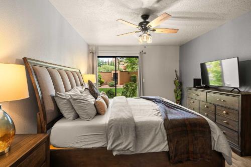a bedroom with a bed with a ceiling fan and a dresser at Charming Sedona Stay with Community Spa & Pool in Sedona