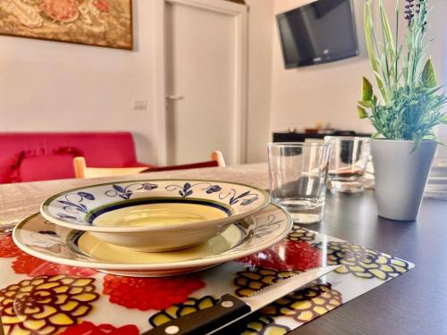 a table with a bowl and a plate on a table at La Dimora del Borgo - Panoramic View in Pitigliano