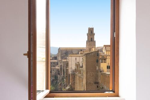 an open window with a view of a city at La Dimora del Borgo - Panoramic View in Pitigliano