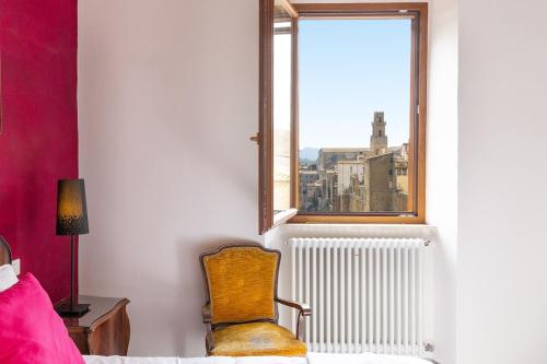 a bedroom with a chair and a window at La Dimora del Borgo - Panoramic View in Pitigliano