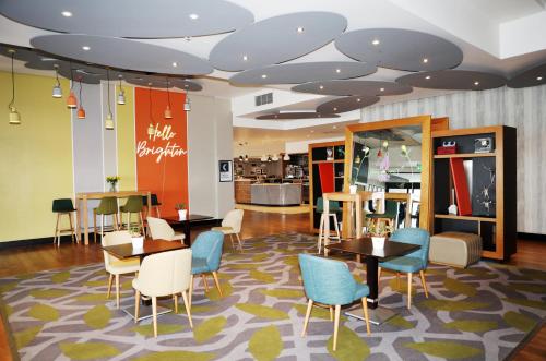 a restaurant with tables and chairs in a mall at Holiday Inn Brighton Seafront by IHG in Brighton & Hove