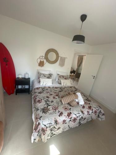 une chambre avec un lit avec un couvre-lit fleuri dans l'établissement Maison cosy à 10 minutes de la plage, à Gujan-Mestras