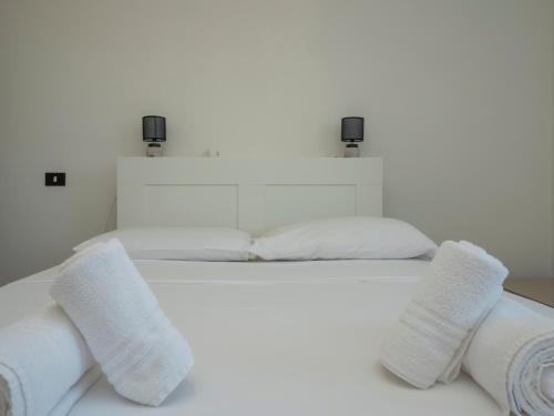 a white bed with white pillows on top of it at I-Host Apartment - Omero 17 in Milan