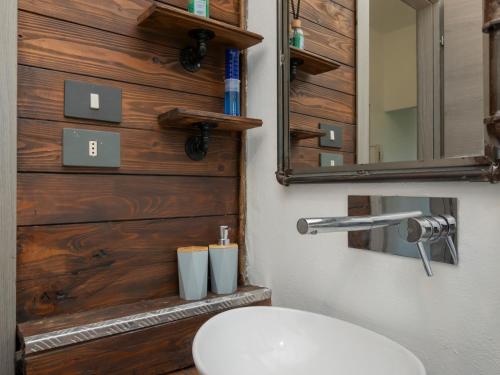 a bathroom with a white sink and a wooden wall at I-Host Apartment - Omero 17 in Milan