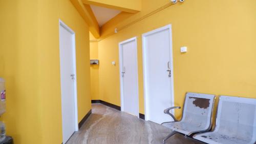 an empty room with two doors and a chair at Easy Stay Eranhipalam in Kozhikode