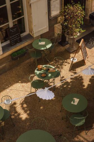 a group of tables and chairs in front of a building at Hôtel du Mail in Angers
