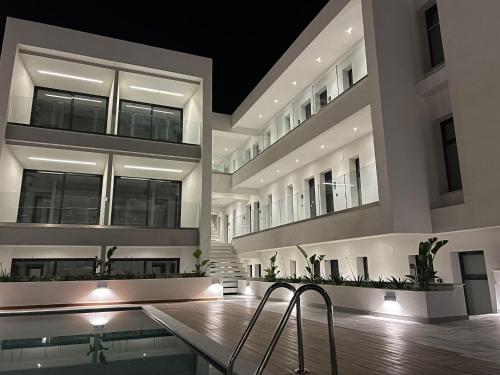 a large building with a swimming pool and two chairs at Diamond 3 in Kallithea Halkidikis