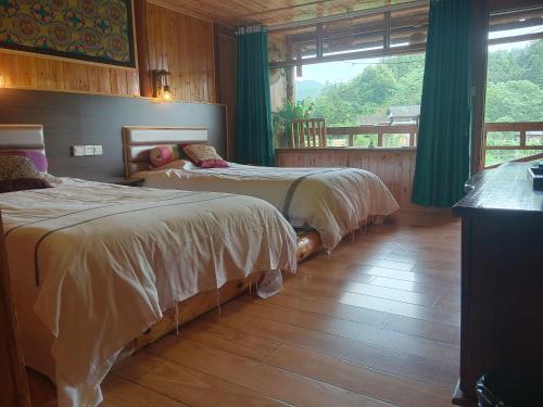 two beds sitting in a room with a window at Bridge View Boutique Guesthouse 望桥楼精品民宿 in Sanjiang