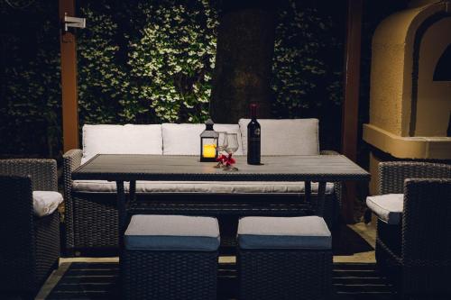 a table with a bottle of wine and a candle on it at Thalassa Luxury Apartments - Korinos in Skála Korinoú