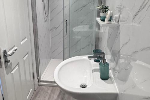 une salle de bain blanche avec un lavabo et une douche dans l'établissement Studio Sleeps3- CloseTo OldTrafford - WhP- o2, à Manchester
