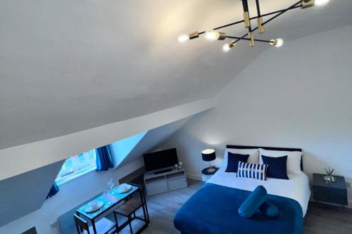 une chambre avec un lit bleu et une chaise bleue dans l'établissement Studio Sleeps3- CloseTo OldTrafford - WhP- o2, à Manchester
