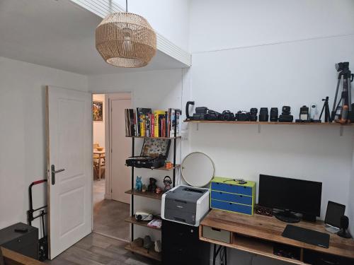 Cette chambre comprend un bureau avec un miroir et une télévision. dans l'établissement Chambre 2 Maison Biarritz proche plage, à Biarritz