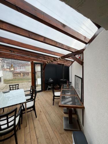 a room with tables and chairs on a wooden deck at Къща Христини in Kalofer