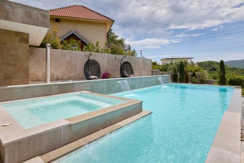 a swimming pool in front of a house at Villa Oaza with Outdoor Pool in Kotor