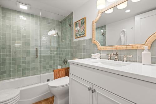 bagno con lavabo, servizi igienici e specchio di Beachfront Aldea 12 a Clearwater Beach