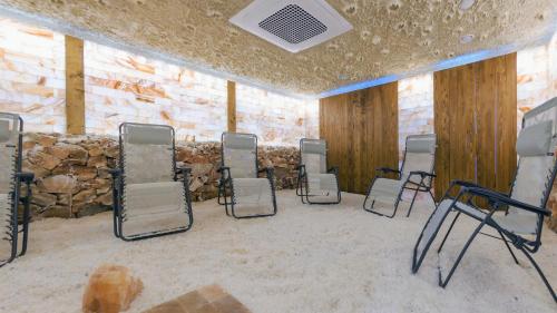 a group of chairs in a room with a stone wall at Sand Dunes, Sun & Snow in Dziwnów