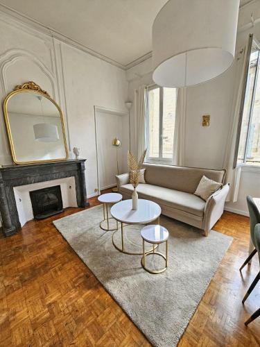 un salon avec un canapé, une table et un miroir dans l'établissement Le Faramineux, Élegant 2 chambres, à Avignon