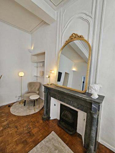 un salon avec une cheminée et un miroir dans l'établissement Le Faramineux, Élegant 2 chambres, à Avignon