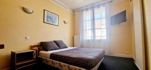 - une chambre avec un lit en face d'une fenêtre dans l'établissement Hôtel de la cloche, à Vitry-le-François