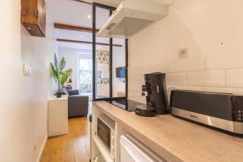 une cuisine avec un comptoir avec un micro-ondes dans l'établissement Le Petit Paradis, à Marseille