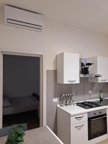 a kitchen with white appliances and a room with a bed at San Francesco Home in Terni