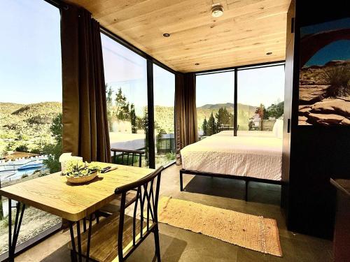 ein Schlafzimmer mit einem Bett und einem Tisch mit Aussicht in der Unterkunft Mirror House Overlook at East Zion Resort in Orderville