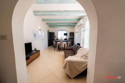 a living room with a couch and a tv at Taz-Zuzu, The Gozo Retreat for Dreamers & Doers in Sannat