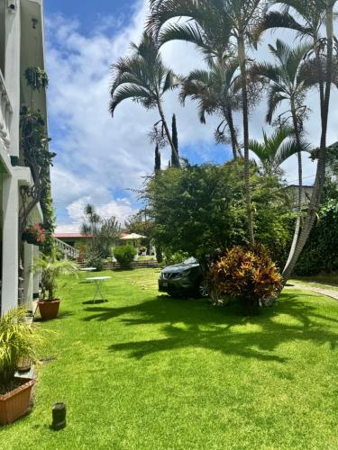 a car parked in a yard with palm trees at Hotel Posada Kamol Bey in Panajachel